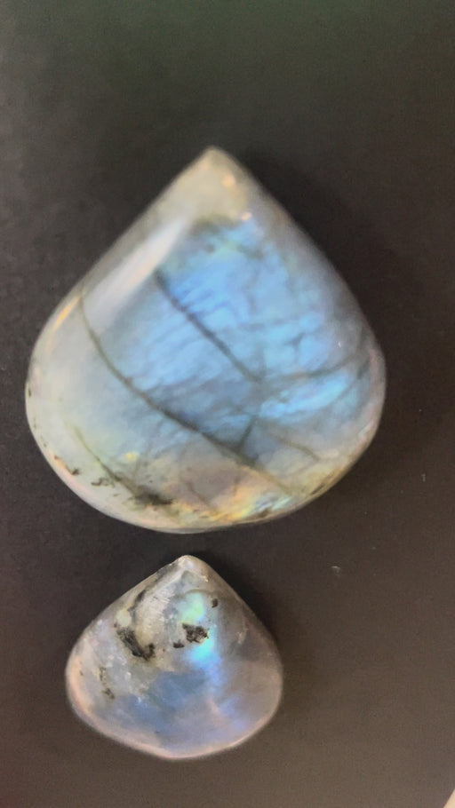 TWO LABRADORITE CRYSTALS ON BLACK BACKGROUND