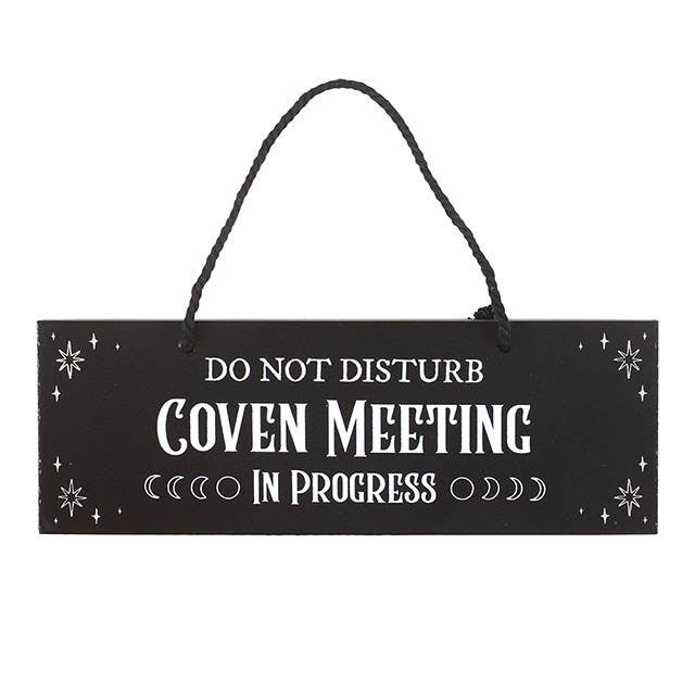 Black sign with white text 'Do Not Disturb Coven Meeting In Progress' on a white background