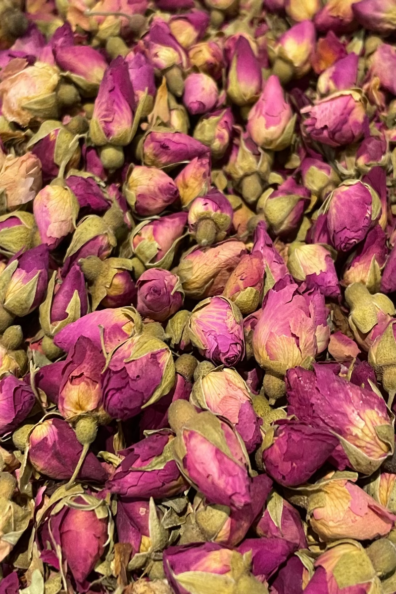 Close-up of dried red rose buds with green leaves